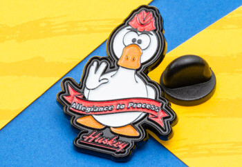 Enamel lapel pin featuring a white duck mascot wearing a red hat with a banner reading Allegiance to Process and Huskey text at the bottom.