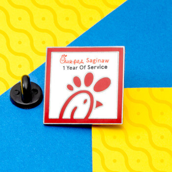 Chick-fil-A Saginaw 1 Year of Service square lapel pin with red logo on a white background and red border.
