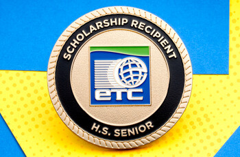 Gold challenge coin for an ETC Scholarship Recipient H.S. Senior featuring a blue globe logo and rope edge.