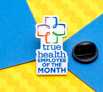 True Health Employee of the Month lapel pin with a colorful cross logo and blue text on a white background.