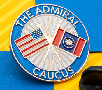 Circular lapel pin for The Admiral Caucus featuring the American and Mississippi state flags with a sunburst background and a black rubber clutch.