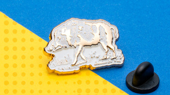 Gold-rimmed bison lapel pin with white enamel fill on a yellow and blue background.