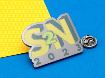 S2N 2023 custom lapel pin featuring yellow and grey enamel on a blue and yellow background.