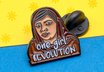 Enamel lapel pin featuring an illustration of a woman in a headscarf with the text One Girl Revolution.